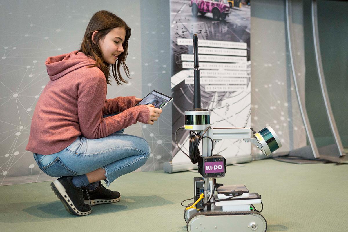 Ein Mädchen steuert einen Roboter