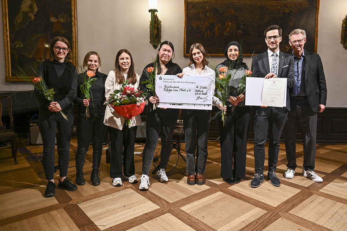 Vertreterinnen der Refugee Law Clinic Freiburg mit einem Spendenscheck