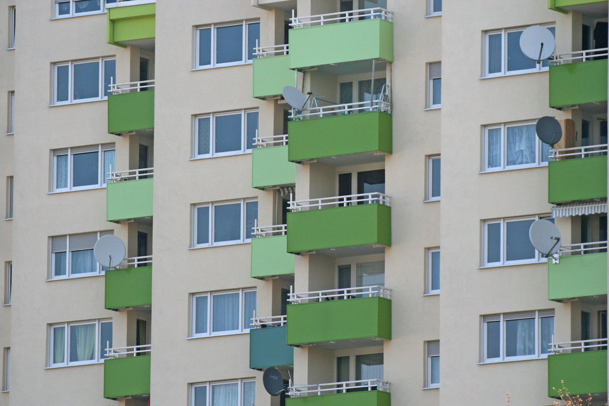 Mietshaus mit grünen Balkonen