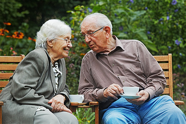 Seniorin und Senior trinken Kaffee im Garten