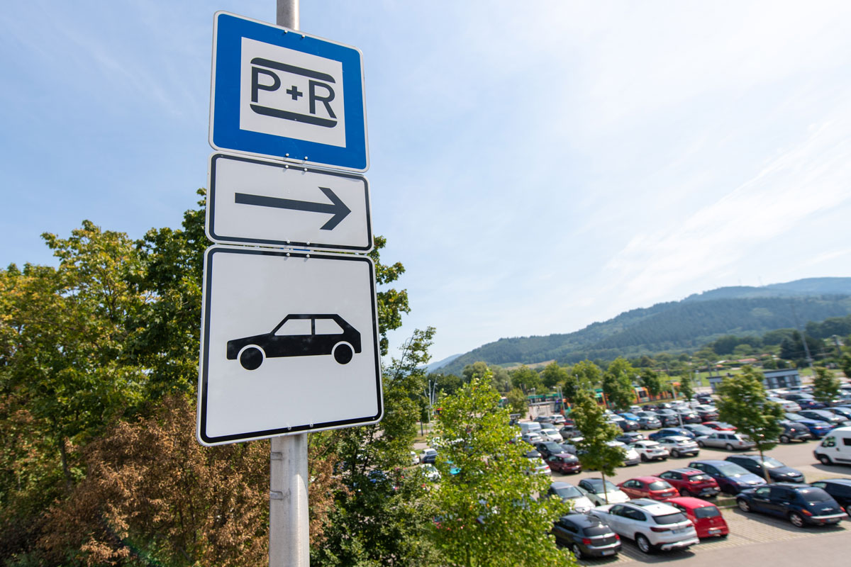 P+R-Schild mit Pfeil; im Hintergrund Autos