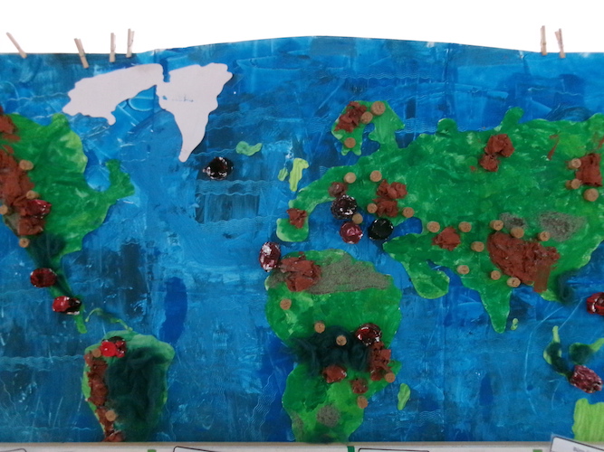 Eine gemalte Weltkarte mit Punkte darauf.