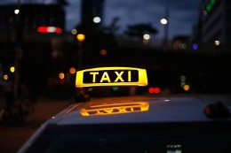 Ein beleuchtetes Taxischild auf einem Taxi