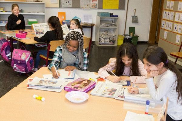 Schülerinnen sitzen mit Papier und Stift am Schreibtisch im Klassenzimmer (Foto: A. J. Schmidt)