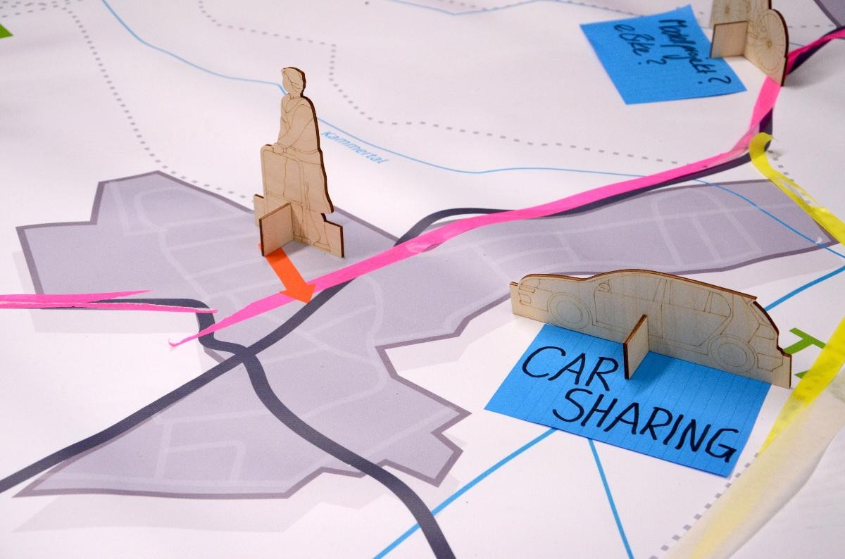Plandarstellung mit der Tiengen-Abgrenzung mit Holz-Modellaufstellern für Car Sharing, arrierefreie Fussläufigkeit und e_Biks