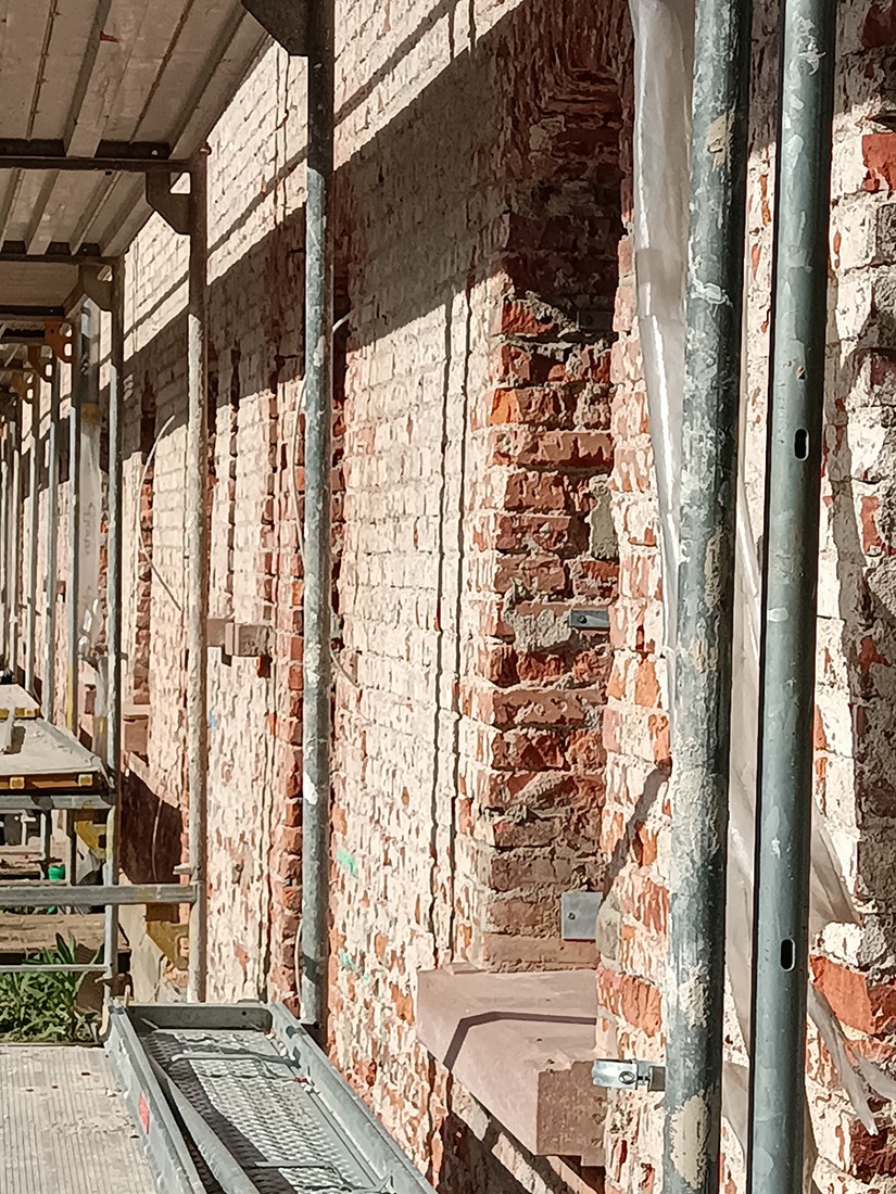 Eingerüstete Backsteinmauern der Knopfhäusle-Siedlung