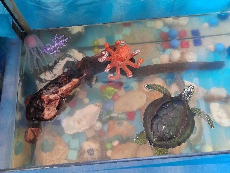 In einem Aquarium sind Wassertiere aus Plastik.