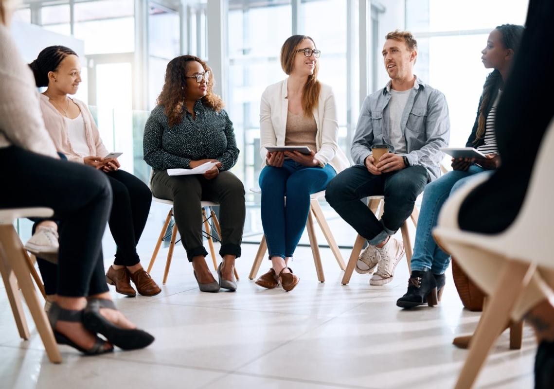 Lockerer Stuhlkreis, Menschen reden miteinander in einem Raum.