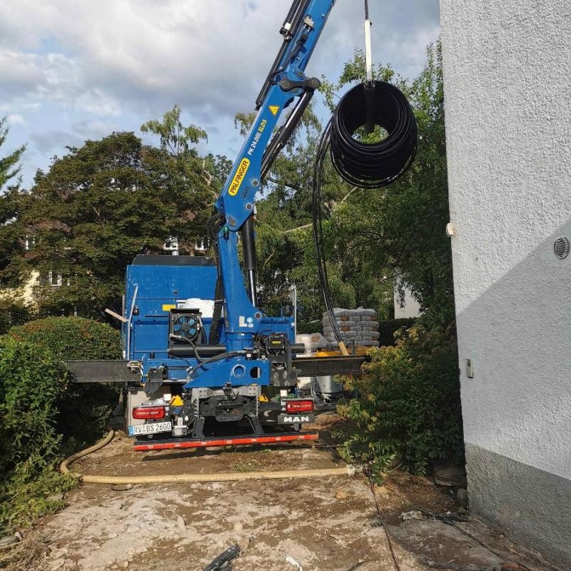 Leitungen werden verlegt Ein Kran verlegt unterirdische Leitungen