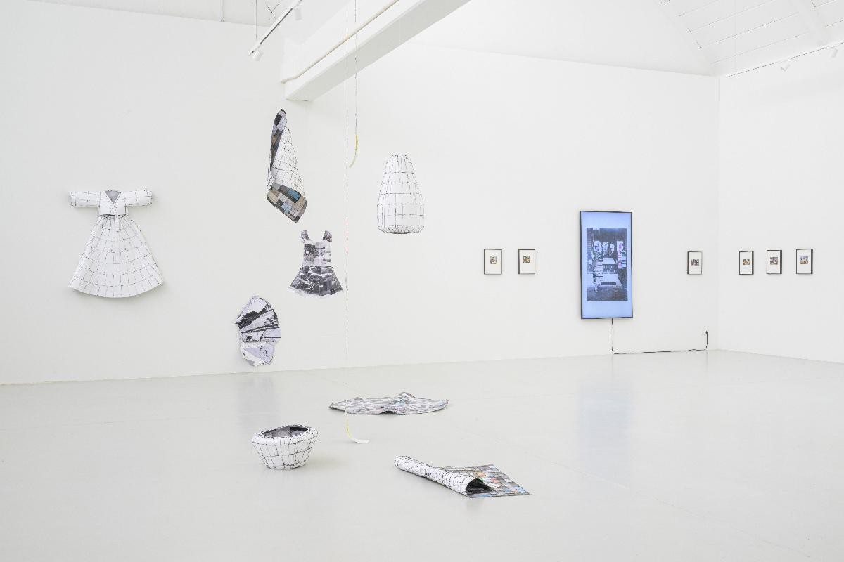 Foto: Marc Doradzillo Ausstellungsansicht der Installtion "Connected Spaces" von Gisoo Kim. Mehrere Objekte, die aus zuammengenähten Fotografien bestehen und Gestalt annehmen, etwa ein Kleid, Vasen, Kokons. Im Hintergrund die Virdeoinstallation von Lily Lulay