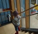 Ein Kind läuft eine Treppe hinunter. An den Fenstern daneben hängt ein Laufbilderbuch.