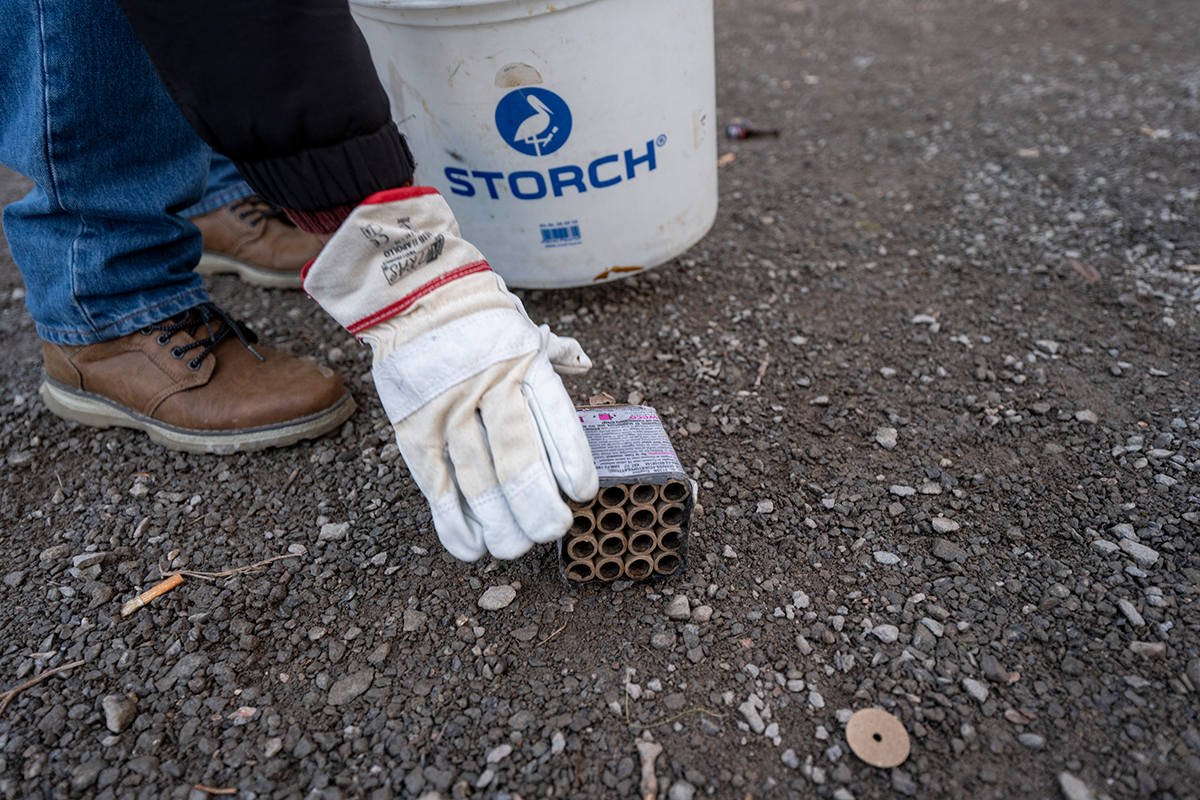 Hand mit Handschuh hebt Raketenreste auf Hand mit Handschuh hebt Raketenreste auf