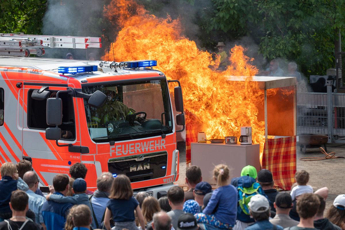 Feuerwehrauto und im Hintergrund Flammen
