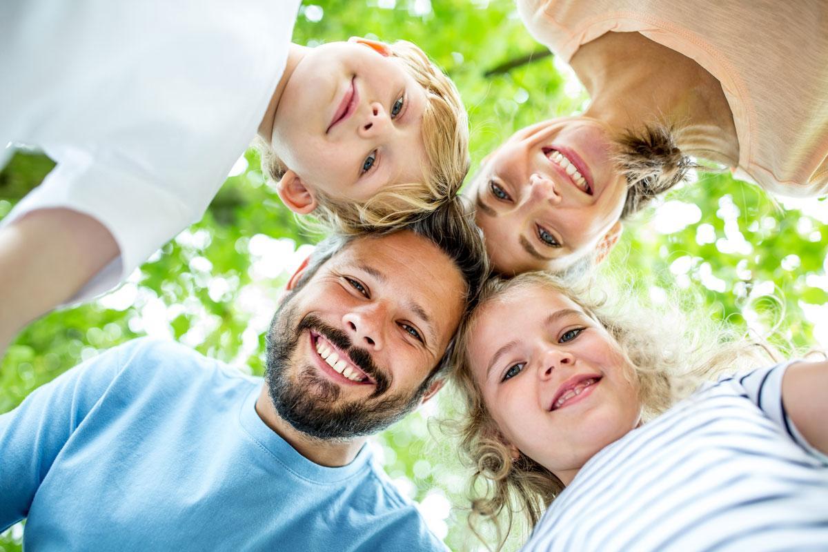 Eine Familie, die ins Bild schaut und lächelt