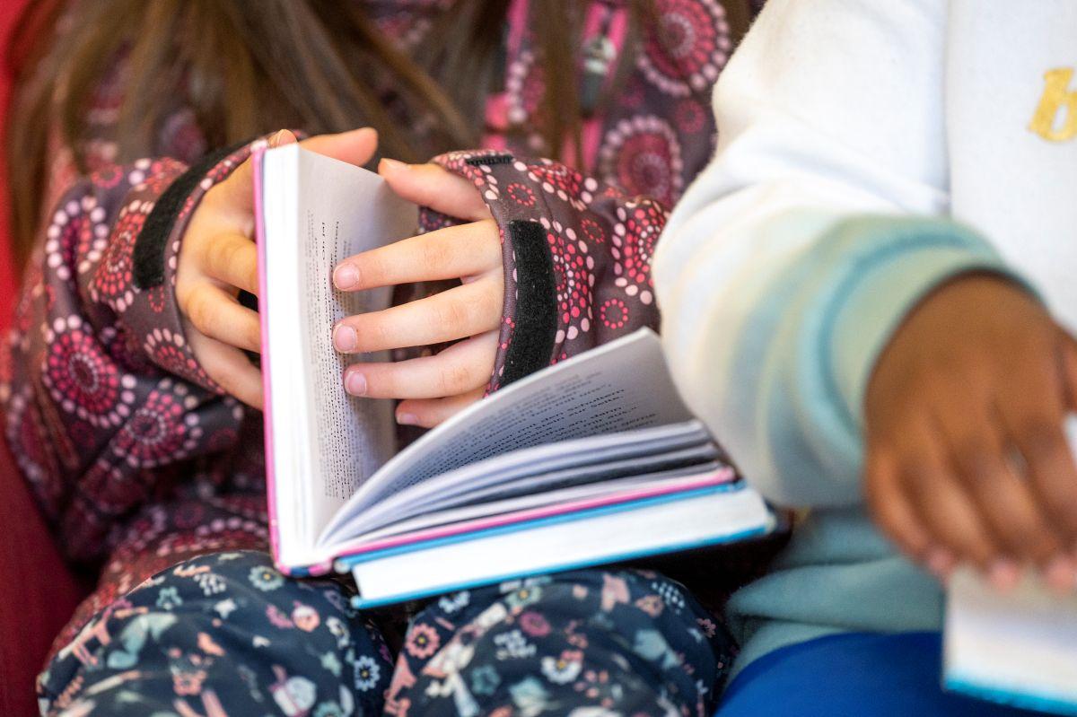 Ein Kind blättert durch ein Buch.