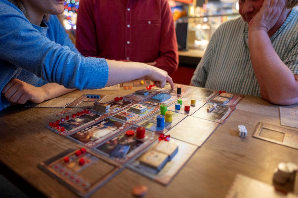 Menschen spielen ein Brettspiel.