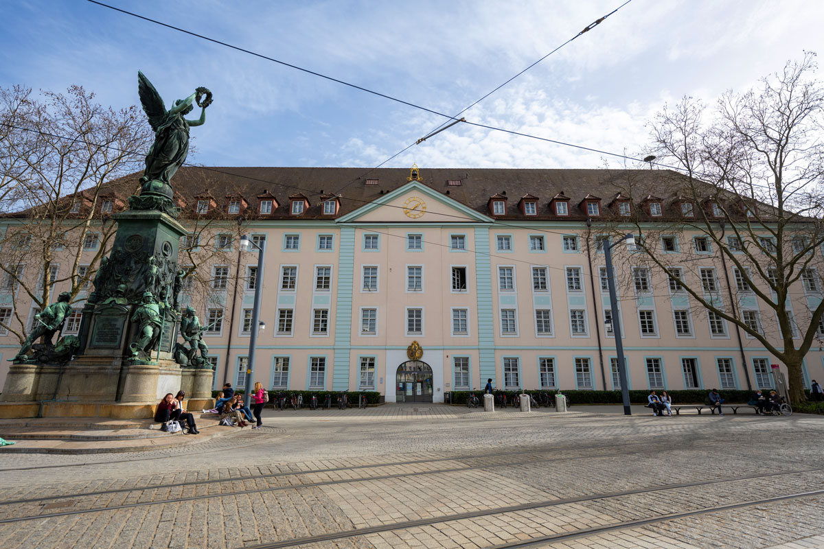 Historisches Gebäude mit Denkmal davor