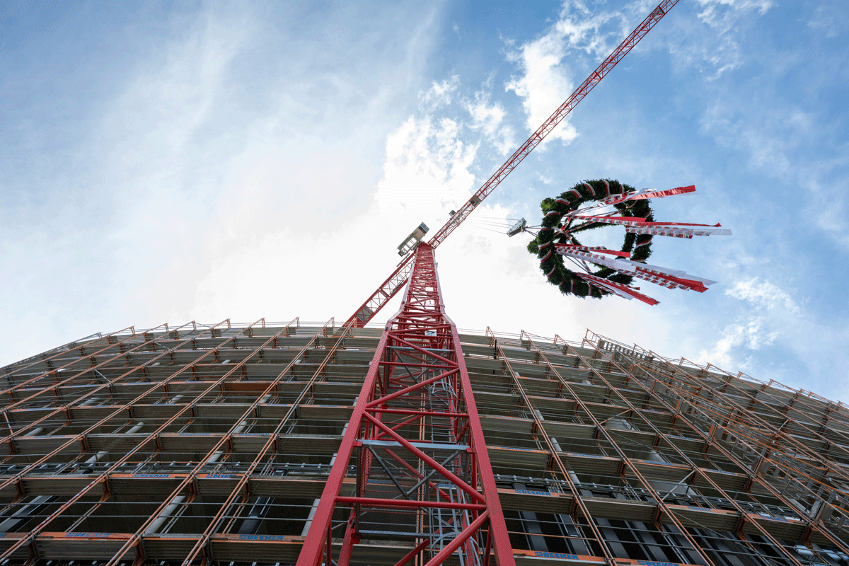 Richtfest-Kranz an einem Kran, im Hintergrund neues Rathaus-Gebäude