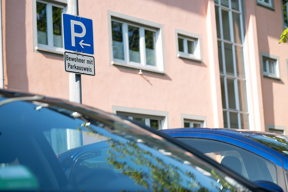 Parkende Autos und Schild mit der Aufschrift "Bewohner mit Parkausweis"