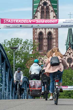 Radfahrende auf der Wiwili-Brücke mit Banner zum Stadtradeln