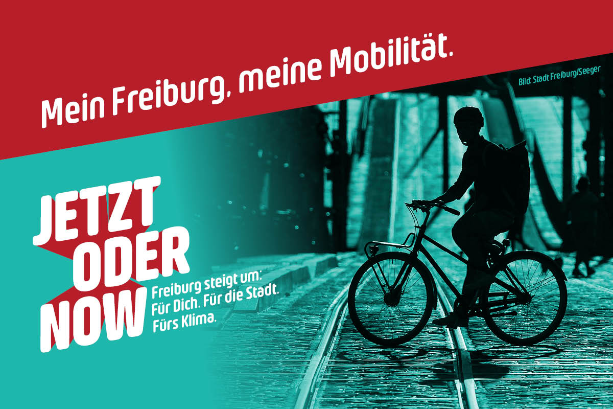 Großer Schriftzug 'JETZT ODER NOW' - Kleiner Schriftzug 'Freiburg steigt um: Für Dich. Für die Stadt. Fürs Klima.'