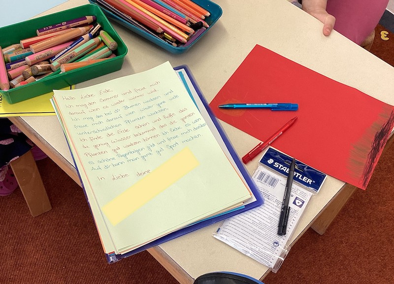 Aus Papier und bunten Stiften entstehen Briefe an die Erde.