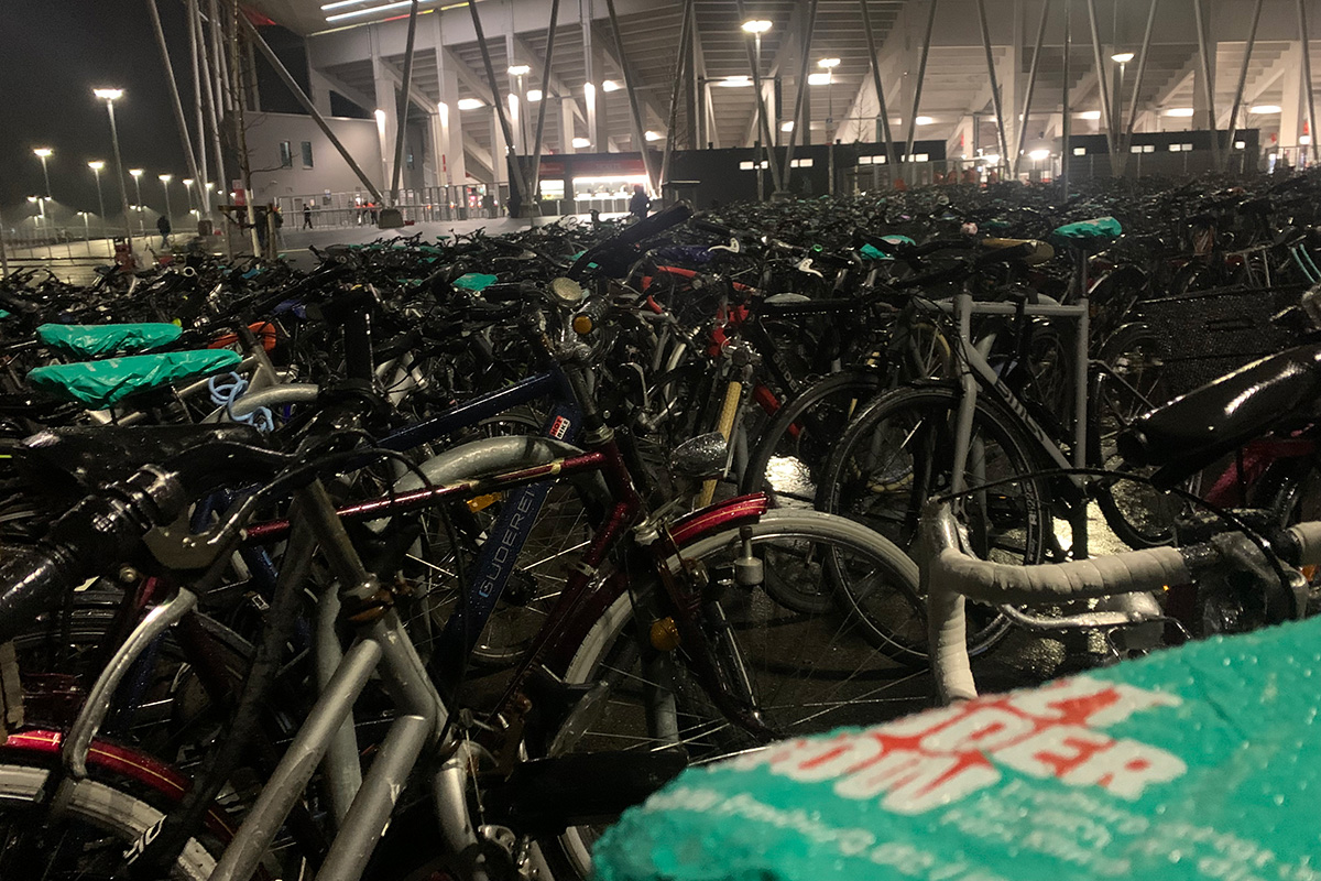 Sattelschoner mit dem Schriftzug "Jetzt oder Now" auf parkenden Fahrrädern vor dem SC-Stadion
