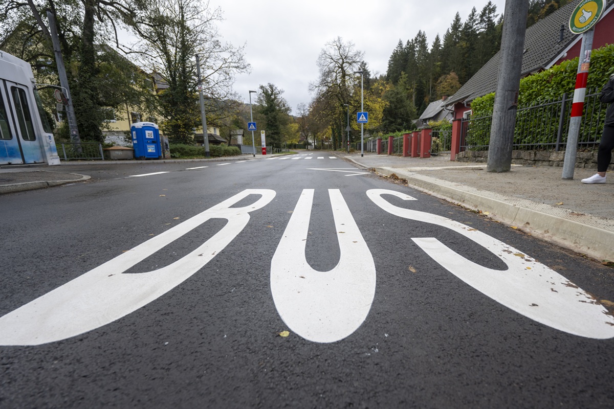 Eine Bushaltestelle. Auf dem Boden in großen Buchstaben steht BUS.