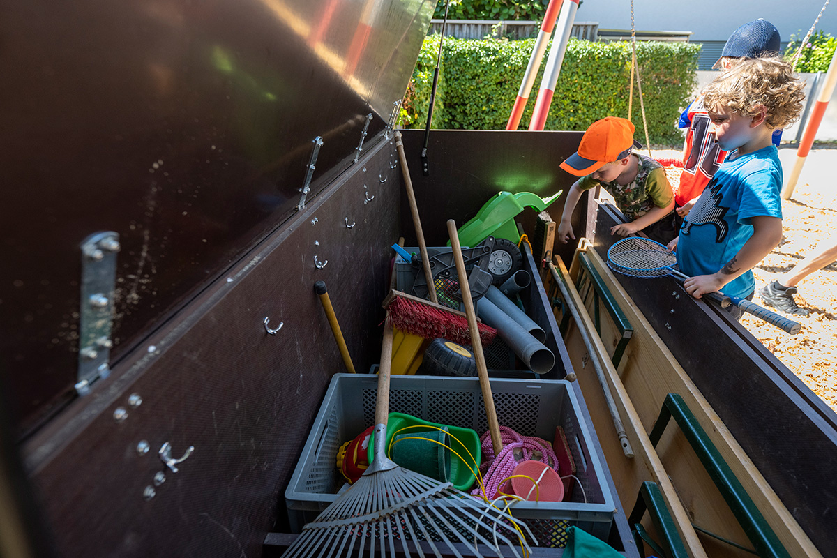Holzkiste mit Spielsachen auf einem Spielplatz