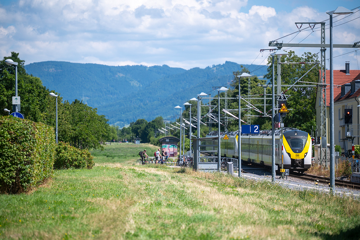 Höllentalbahn auf der rechten Seite, Rasenfläche in der mitte und Hecken und Bäume auf der linken Seite.