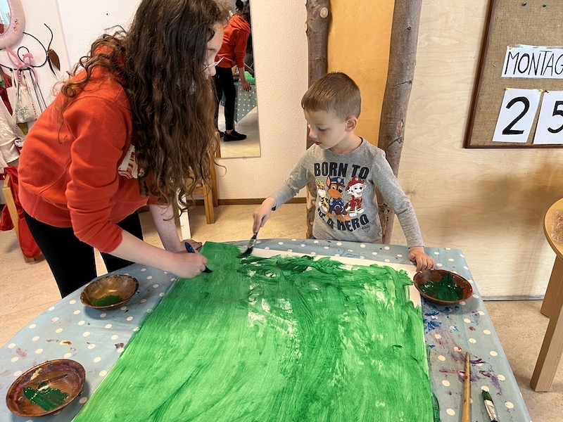 Mit Unterstützung der großen Schwester ist die duftende Blumenwiese noch schneller bemalt.