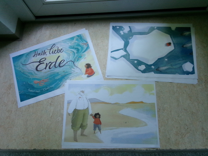 Seiten des Bilderbuches liegen groß ausgedruckt auf dem Boden.