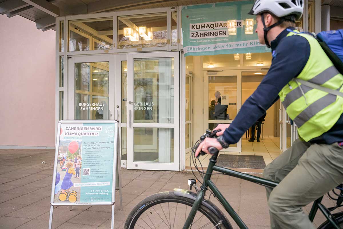 Fahrradfahrer vor Aufsteller "Zähringer wird Klimaquartier"