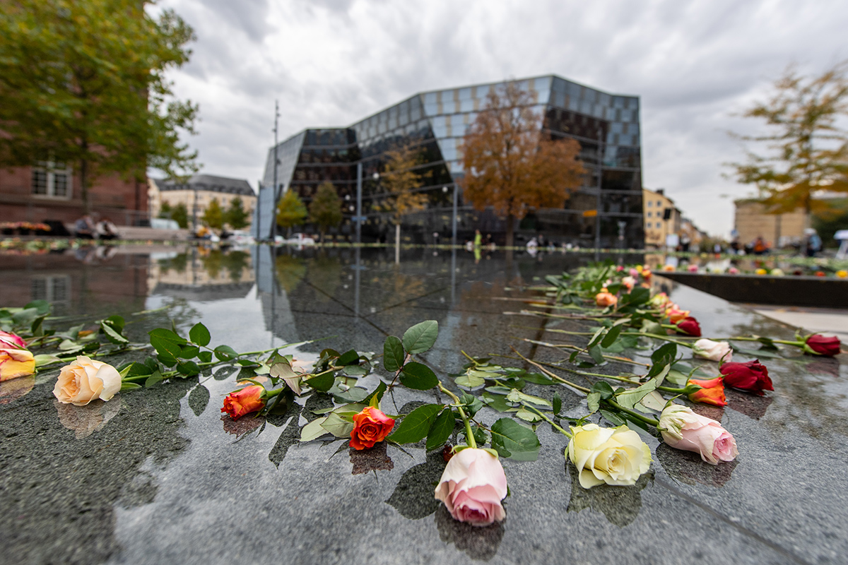 Rosen liegen im Gedenkbrunnen auf dem Platz der Alten Synagoge