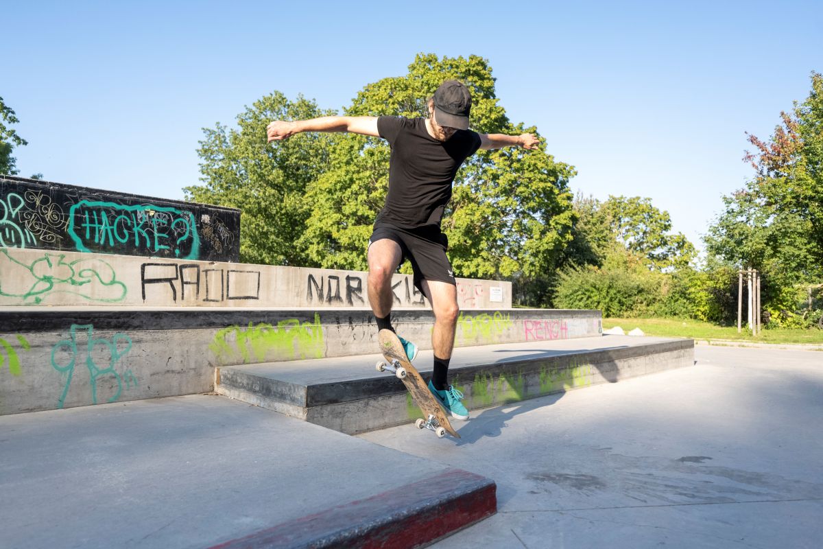 Ein Mann macht Tricks mit dem Skateboard ein einer Halfpipe