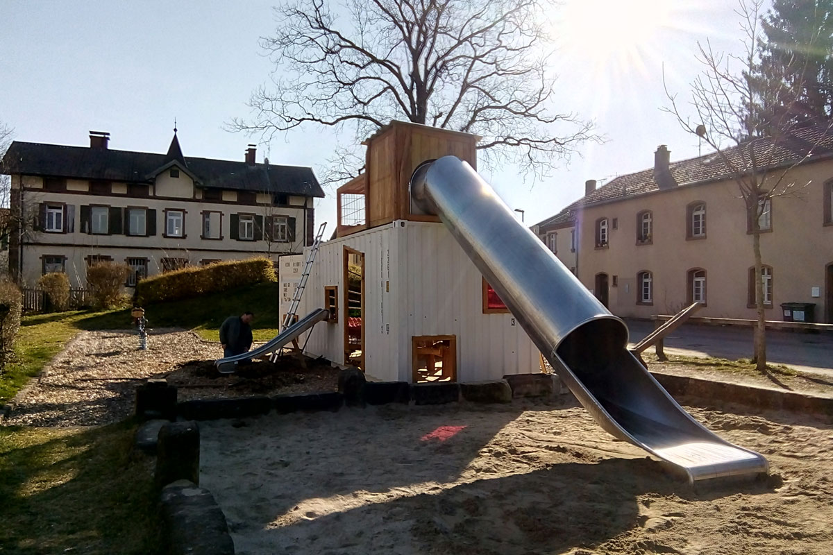 Eine Röhrenrutsche fährt vom Dach des Containers nach unten