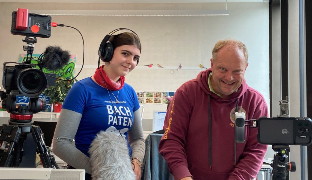 Mann mit Filmkamera und eine junge Frau mit Mikrofon 