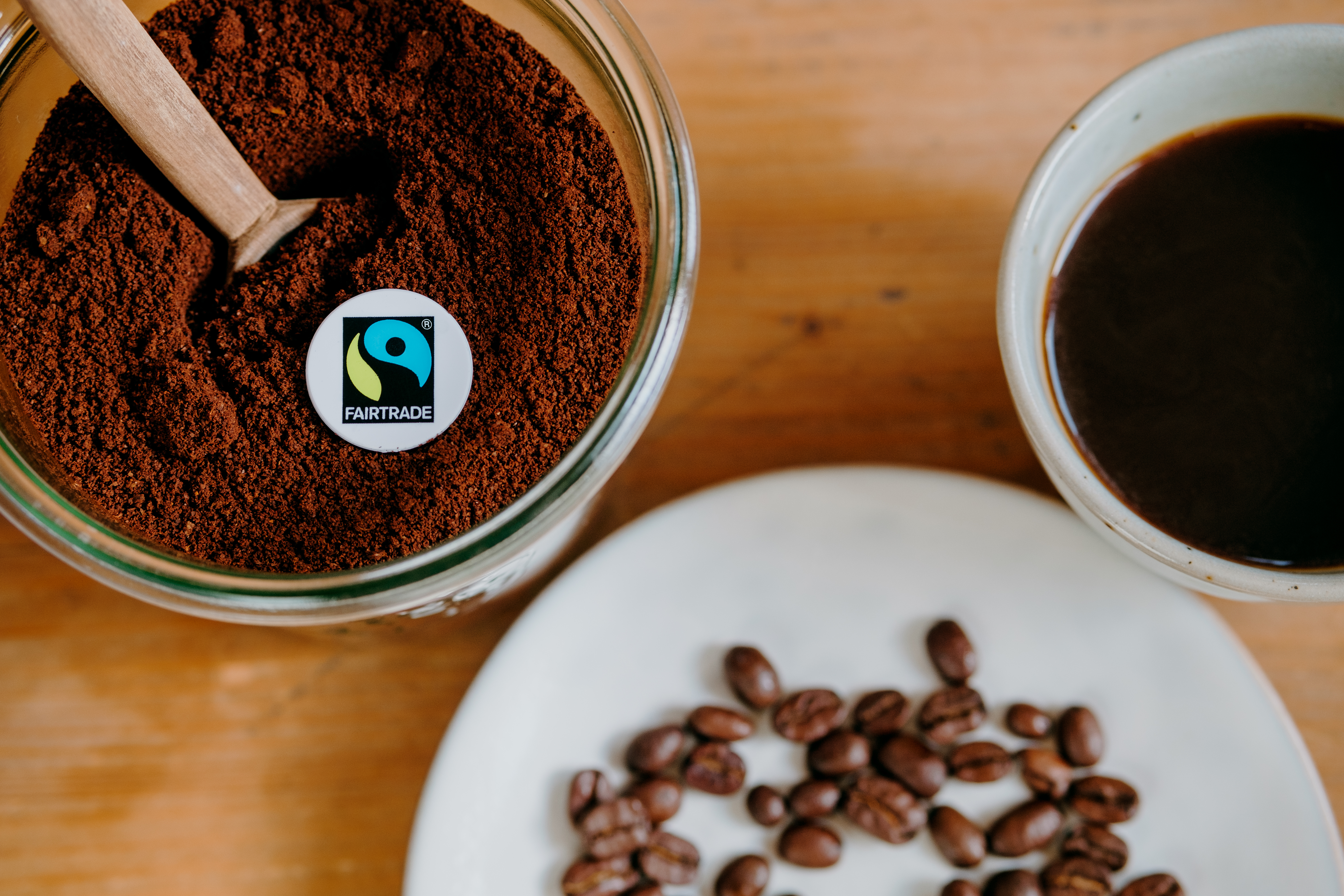 Kaffeepulver, Bohnen und eine Tasse mit schwarzem Kaffee