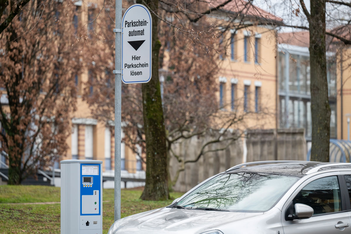Auto steht auf Parkplatz in Wohngebiet, Parkscheinautomat neben dran