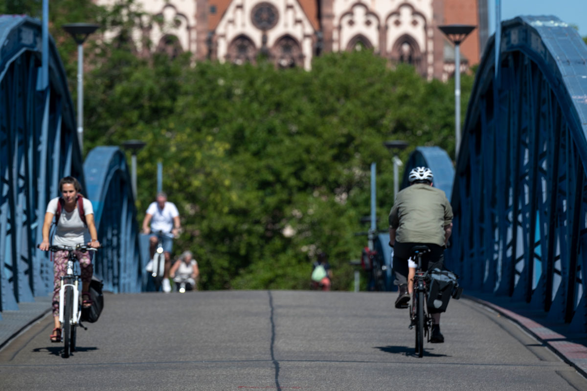 Mehrere Personen fahren mit dem Fahrrad über die Wiwili-Brücke