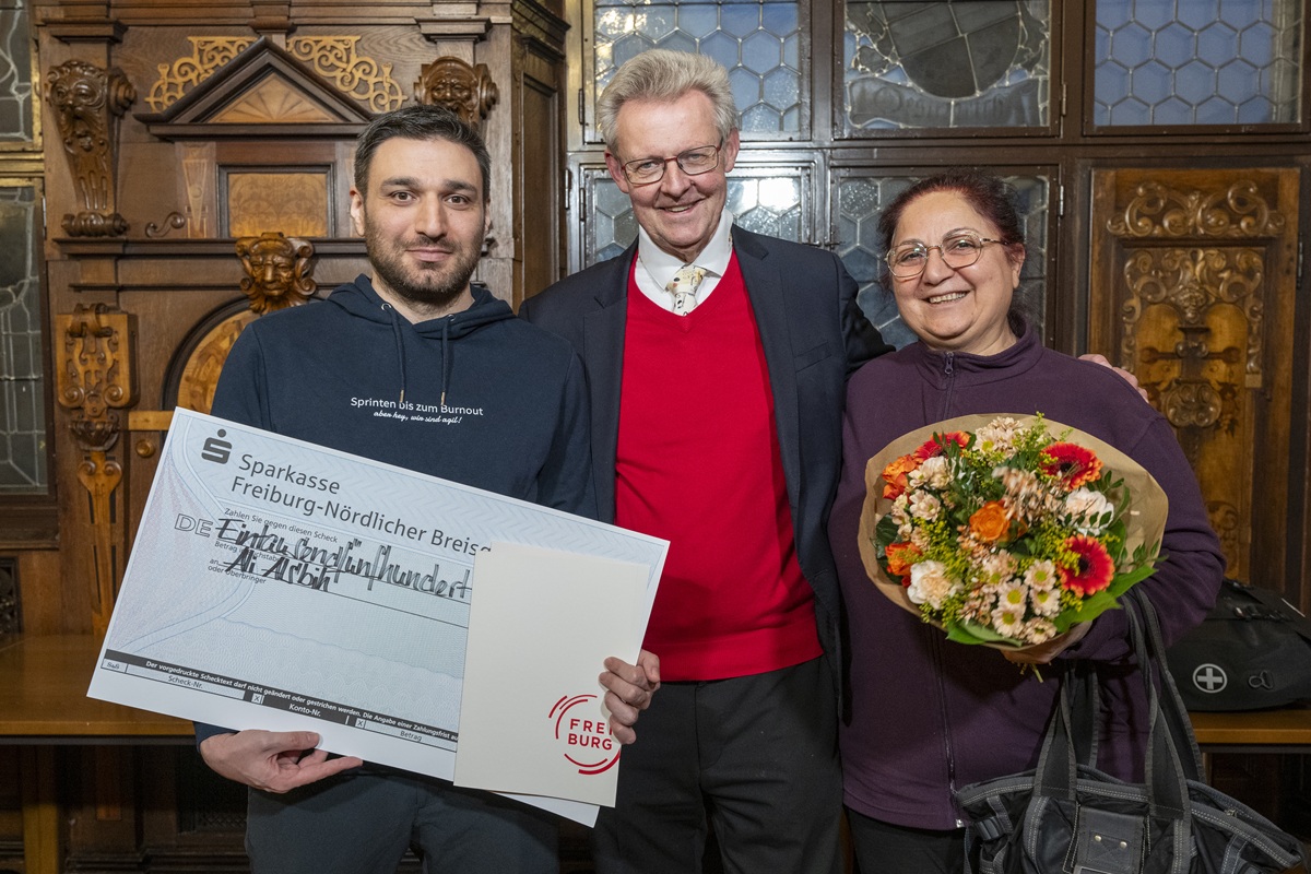 Preisträger Ali Alsbih mit dem Ersten Bürgermeister Ulrich von Kirchbach und der Pflegerin Zoufinar Murad.