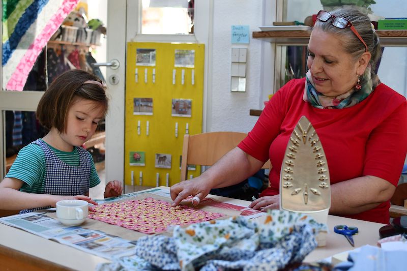 Ein Kind bastelt ein Wachstuch.