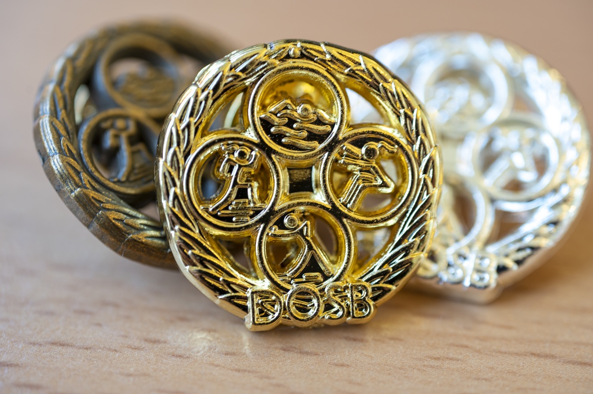 Die drei Anstecker des Deutschen Sportabzeichens in Bronze, Silber und Gold.