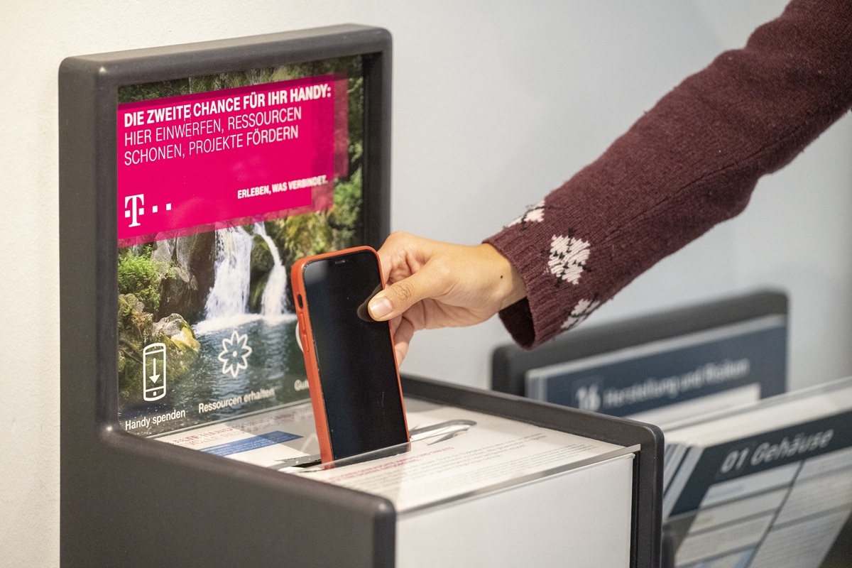 Die Sammelbox im Museum für Mensch und Natur. Eine Person wirft gerade ein Handy hinein.