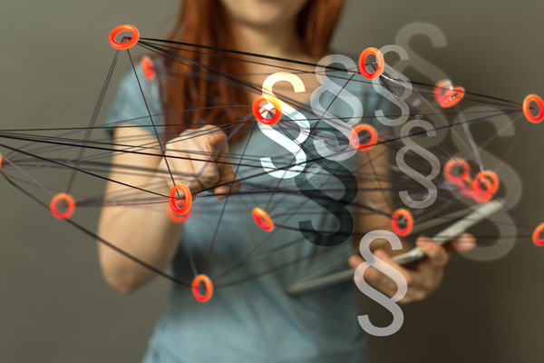 Frau mit Laptop und Paragrafen