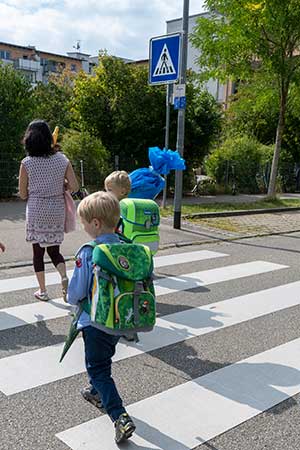 Kinder mit Schultüte auf einem Zebrastreifen