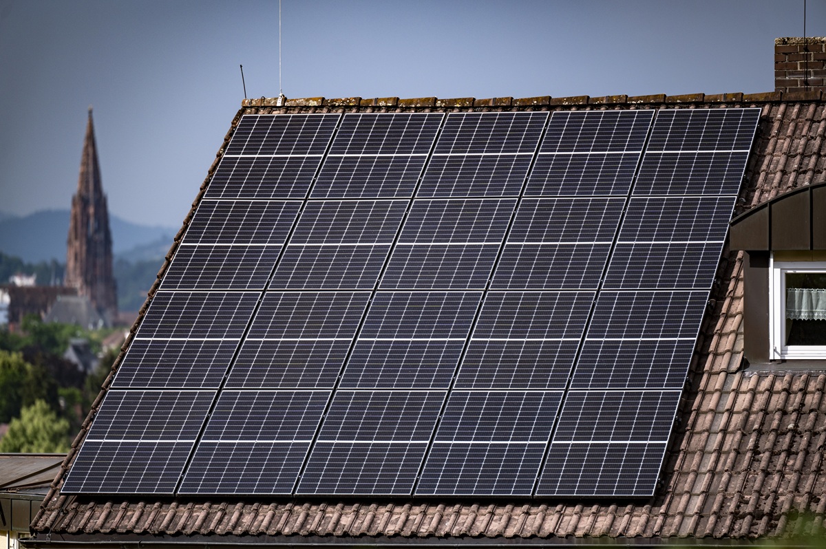 Solarpaneele auf einem Hausdach, im Hintergrund sieht man das Münster.