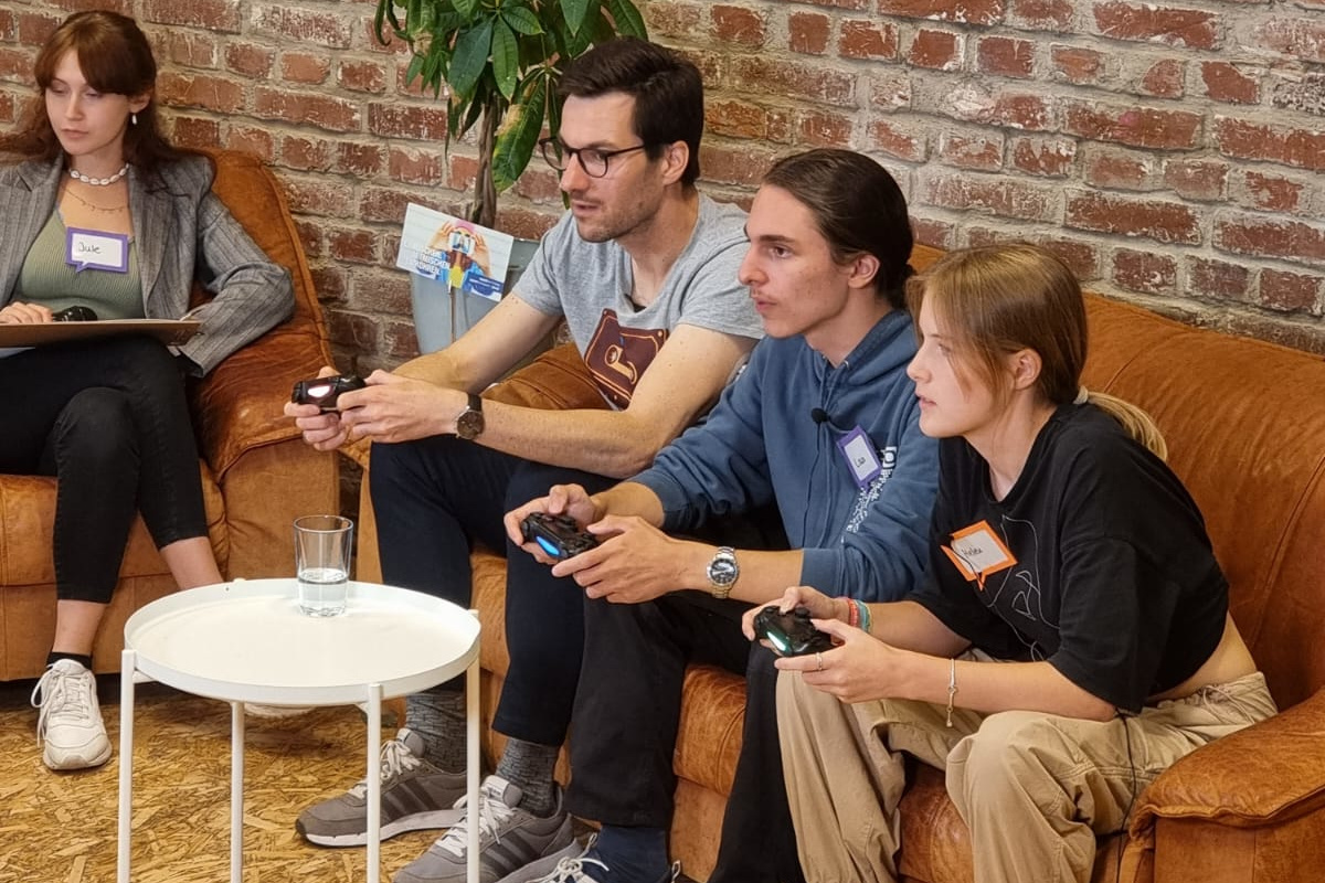Oberbürgermeister Martin Horn und Jugendliche auf einer Couch beim gemeinsamen Computerspielen