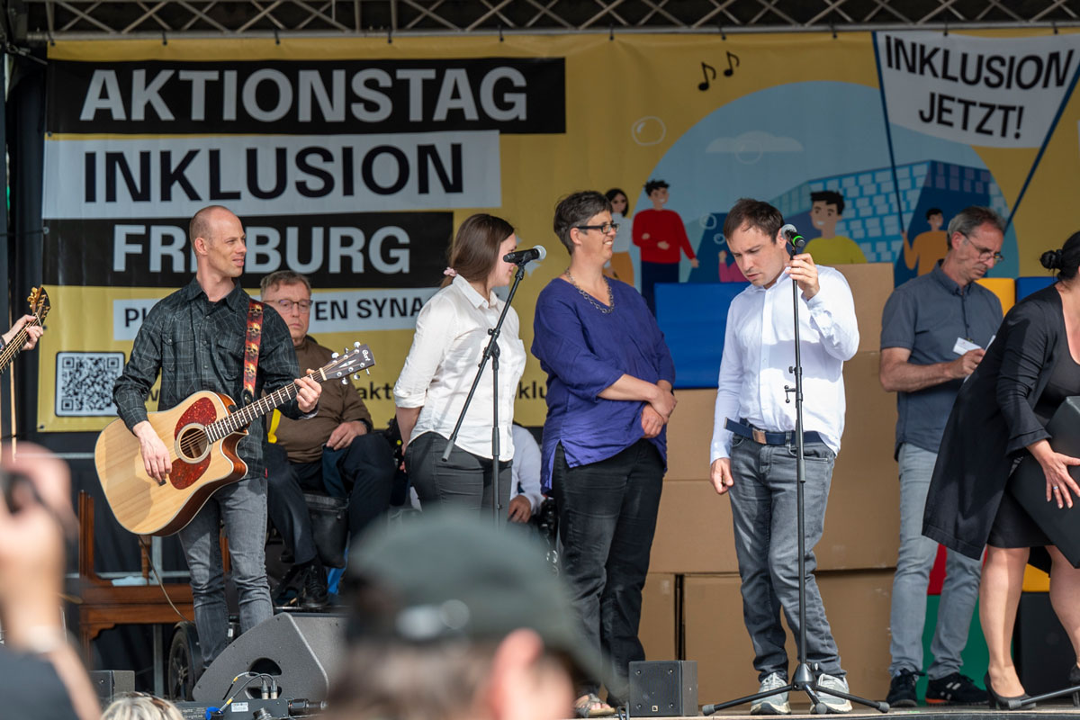 Musiker*innen und Redner*innen auf einer Bühne