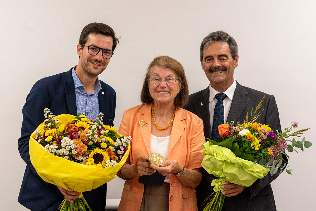 Martin Horn und Bernhard Schätzle mit Blumensträußen, in der Mitte Sigrun Löwisch mit dem goldenen Stadtsiegel